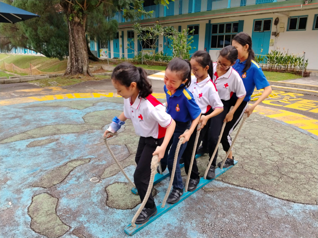 Students working together to balance on team skis during a group challenge.